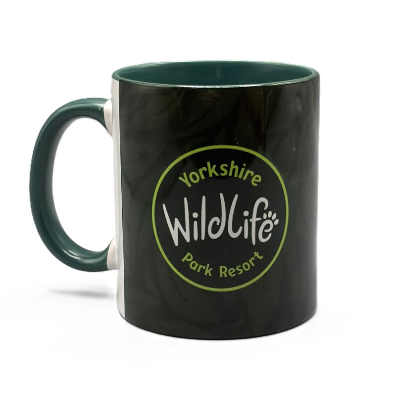 A ceramic mug with a glossy dark green leaf exterior and a dark green handle and interior. The front features a circular green and white logo that reads 'Yorkshire Wildlife Park Resort'.