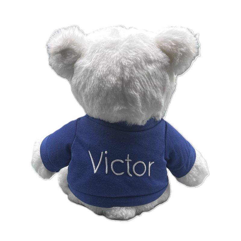 White teddy bear wearing a blue shirt with 'Victor' on a white background
