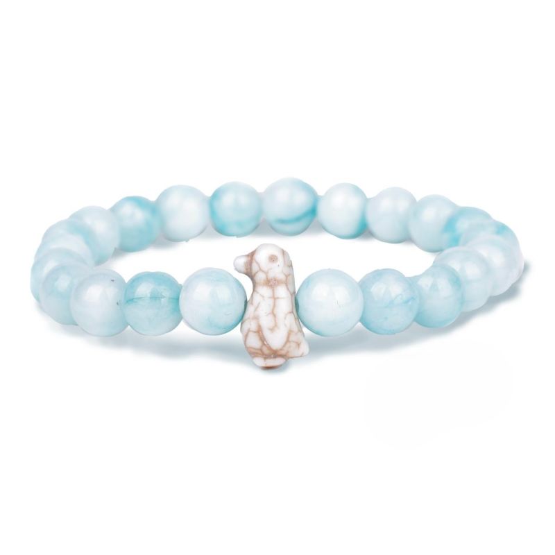 Light blue green beaded bracelet with a dog-shaped charm on a white background