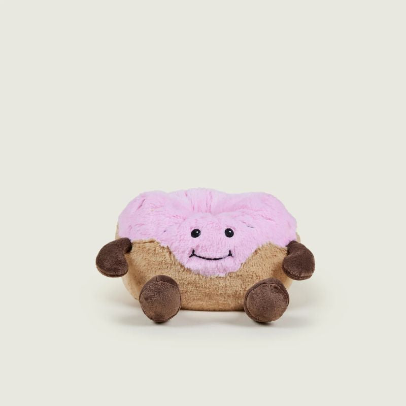 A plush toy resembling a donut with a pink icing topping and chocolate sprinkles, designed to be microwavable for warmth.