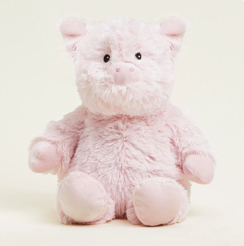 A pink plush toy pig that is fully heatable and can be microwaved to provide warmth.