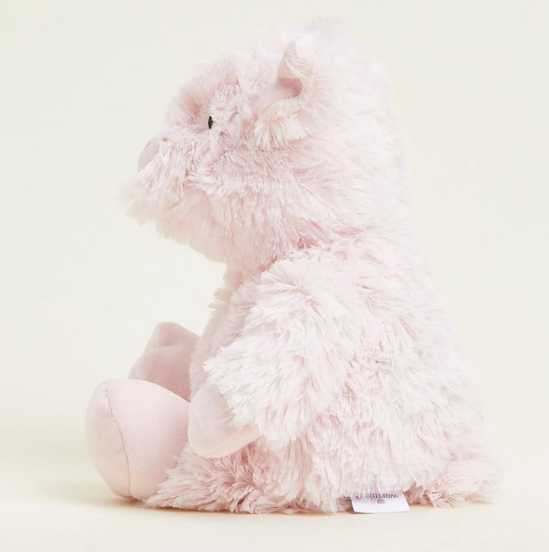 A pink plush toy pig that is fully heatable and can be microwaved to provide warmth.