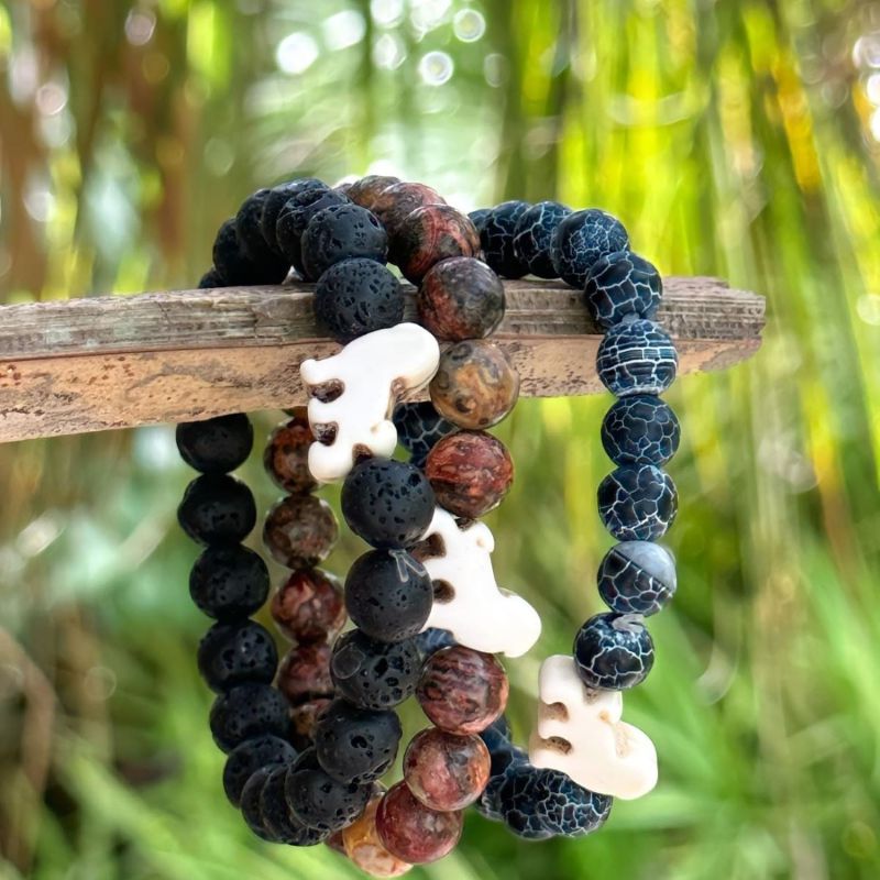 Set of three beaded fahlo lion bracelets with on a branch against a natural background