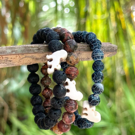 Set of three beaded fahlo lion bracelets with on a branch against a natural background