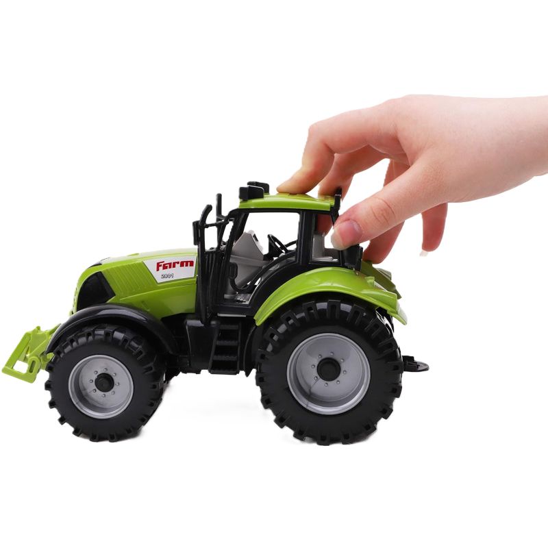 Toy tractor with a hand interacting with it on a white background