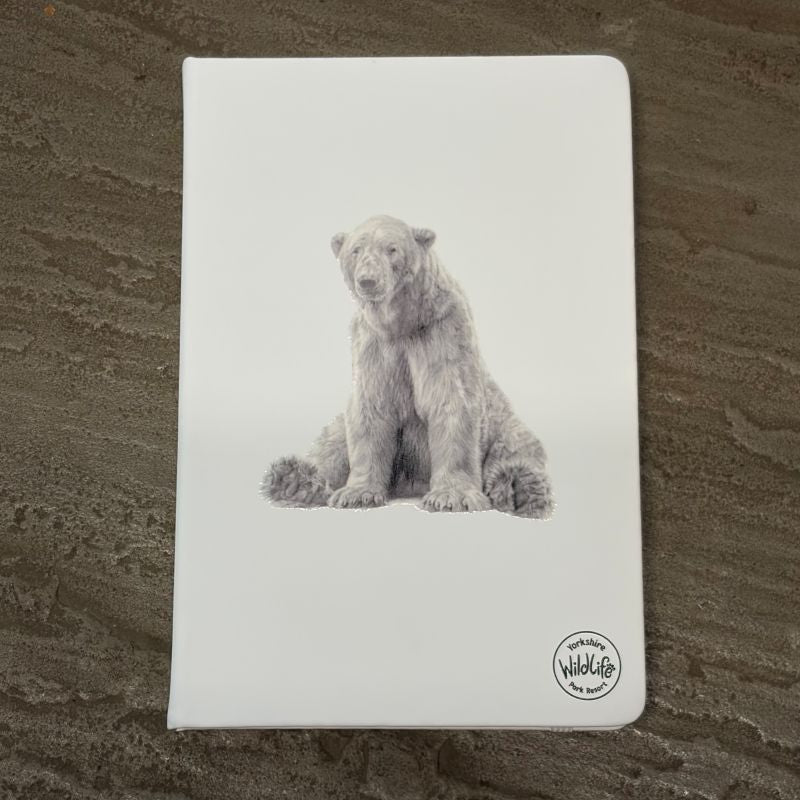 A white hardcover notebook featuring a detailed grayscale illustration of victor the polar bear on the front cover, resting on a textured gray stone surface. The 'Yorkshire Wildlife Park' logo is visible in the bottom right corner.