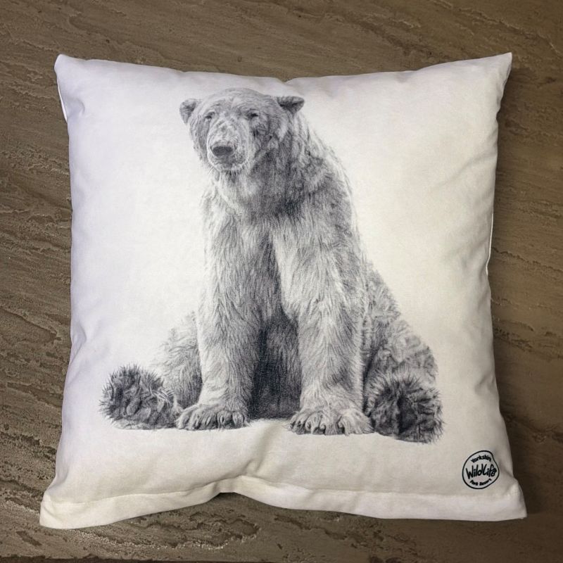 A square white cushion featuring a detailed black and white sketch of victor the polar bear, displayed on a textured grey tile surface.