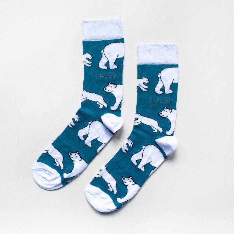 Teal socks with white polar bear patterns on a light gray background