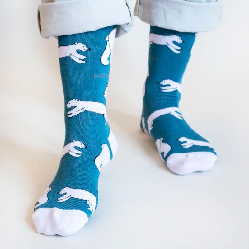 Teal socks with white animal patterns worn by a person on a light background