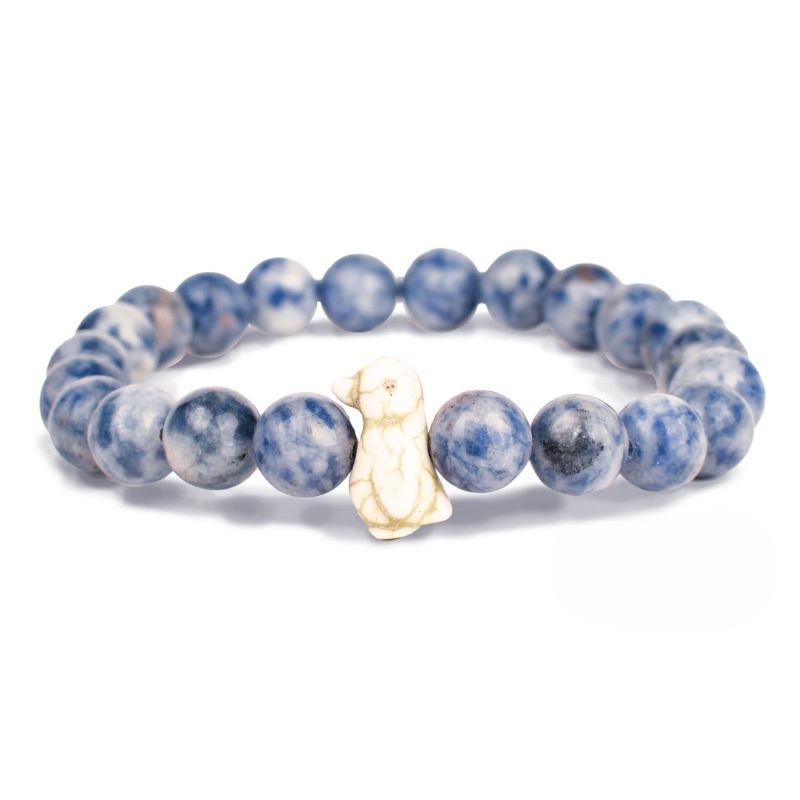 Blue and white beaded bracelet with a gold penguin charm on a white background