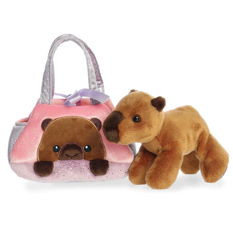 Plush capybara toy next to a pink handbag with a capybara face design on a white background